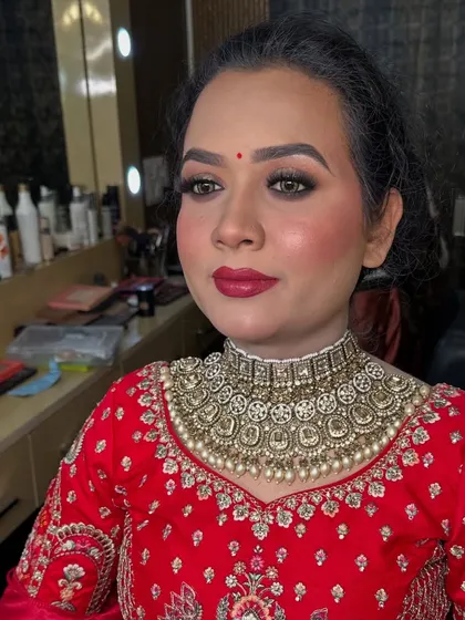 A close up of the final look with a bold red lip. This classic choice is perfect for a traditional bridal ensemble.