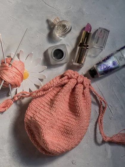 Our little pink crochet potli pouch is perfect for carrying your small essentials like lipstick, keys, and hand cream. The drawstring closure with tassels keeps everything secure.