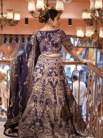 I love mixing modern style with traditional craftsmanship. This deep purple Banarasi lehenga features classic woven peacock motifs, giving it a rich, heritage feel while the silhouette is completely contemporary.