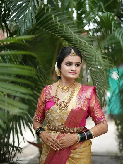 This bride's look is a perfect balance of tradition and elegance. The makeup is kept soft and pretty to complement her beautiful gold jewelry and silk saree.