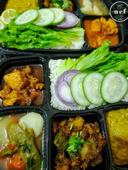 A close-up of my scrumptious chicken and pork thalis, packed with fresh salad and multiple side dishes.