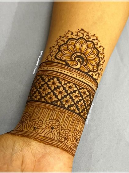 Another angle of the floral and peacock arm band, showing the rich texture and precise line work of the design.