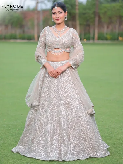 A modern and chic take on the lehenga. This silver-grey creation with a stylish cut-out blouse is perfect for a reception or cocktail party.
