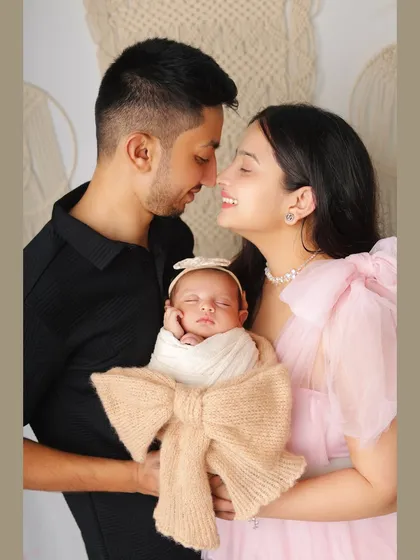 There's nothing more special than a family's first portrait. I captured this beautiful moment with the new parents adoring their sleeping newborn, who is wrapped snugly in a bow-adorned swaddle.