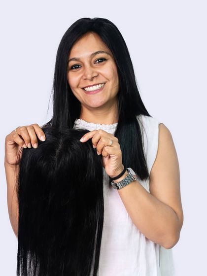 Our clip-in scalp toppers are the ultimate solution for thinning hair. Here, a model displays a topper, showing how it provides coverage while looking completely natural. They are available in mono, silk, and lace bases.