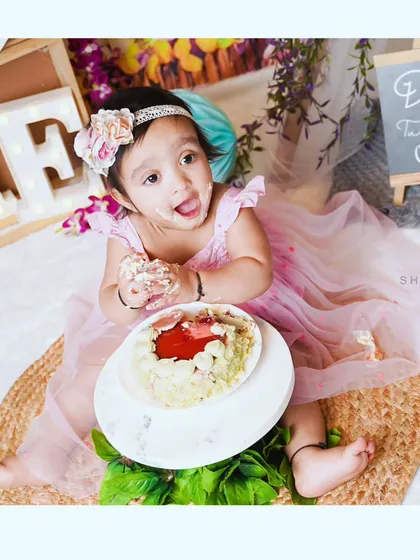 A happy mess. Little Dia is enjoying her first taste of cake during her first birthday cake smash session.