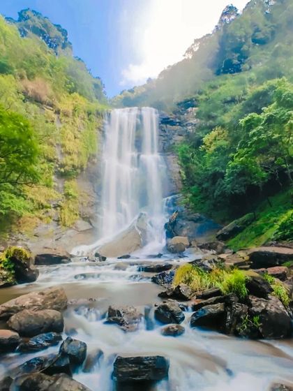 A vibrant, colorful long-exposure of the same waterfall, showing the beauty of the landscape.