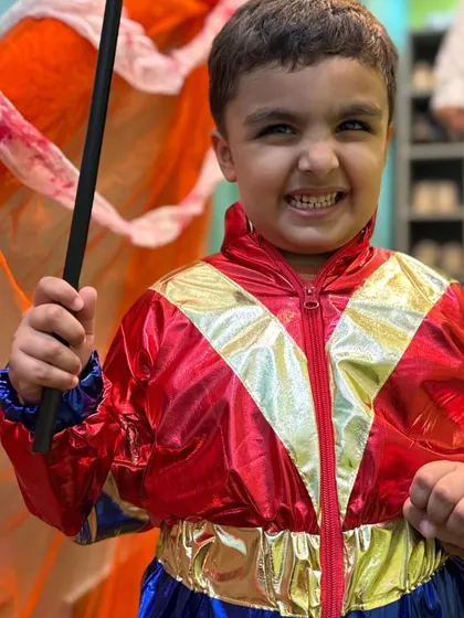 A young superhero in a shiny red and gold costume, feeling powerful and ready for adventure.