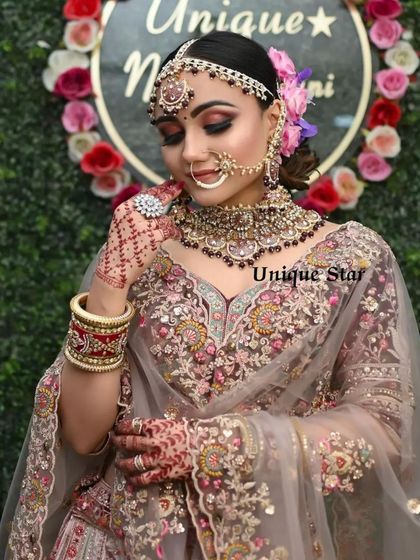 A beautiful pose showcasing the intricate embroidery and jewelry paired with our dusty pink bridal lehenga.