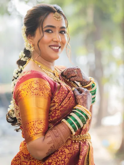 A portrait of the bride, her hair adorned with fresh flowers, a classic element of South Indian bridal style.