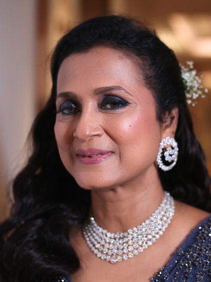 A close-up that highlights her radiant smile and sparkling eyes. The makeup is designed to make her feel like the star of the show.