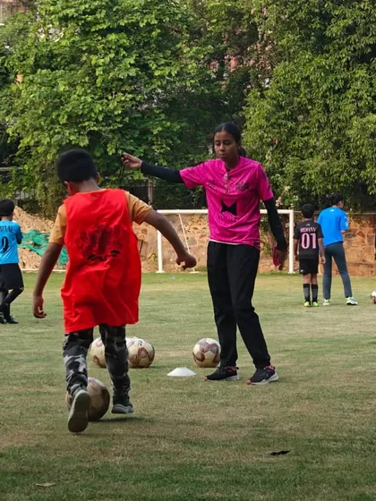 A coach gives instructions to a young player during a drill. We provide personalized guidance to help every child improve.