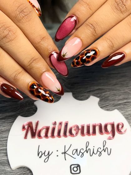 A bold and trendy set combining deep red, sheer pink, and a striking tortoise shell animal print design on almond-shaped nails.