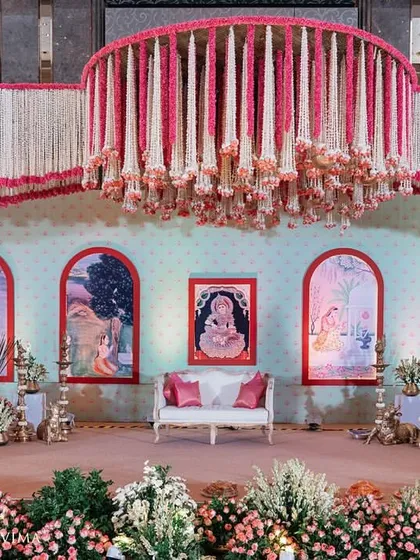 This grand stage was designed for a traditional South Indian half-saree function. The design features intricate floral chandeliers and a backdrop with custom artwork, celebrating a beautiful rite of passage.