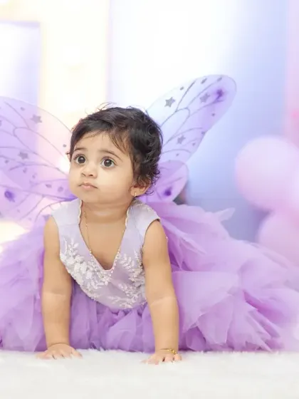 A dreamy portrait of a little one at her first birthday party. The fairy wings and soft lighting create a magical, storybook feel for this milestone photoshoot.