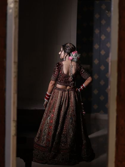 A view of the bridal hairstyle from the back, showing the intricate floral bun that completes this traditional look.