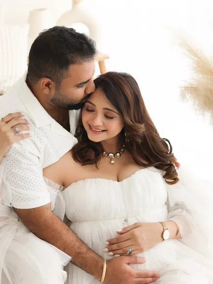 A forehead kiss is always a symbol of deep love and affection. This intimate moment between the couple is perfectly captured in our bright and airy studio.