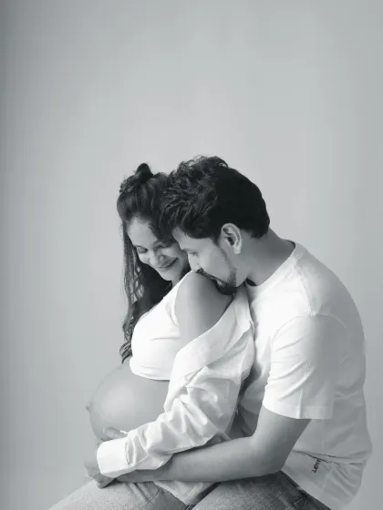 This black and white couple portrait is filled with tenderness. The way he rests his head on her shoulder while she cradles her bump creates a timeless and emotional photograph.