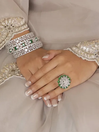 This shot showcases the matching emerald and diamond bangles and ring from our bridal set. Wearing the full set creates a look of complete and coordinated elegance.