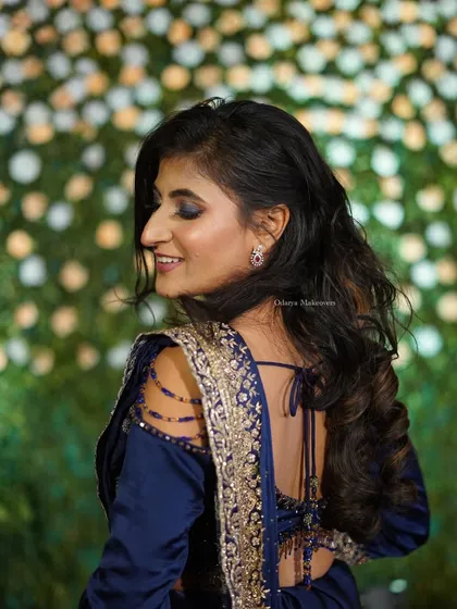 Look at those fluttering eyes. This reception look features a dramatic blue smokey eye that makes her eyes pop, paired with soft, open curls for a touch of glamour.