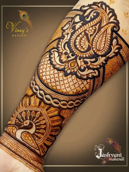 A forearm detail showing a majestic peacock and a large paisley motif, demonstrating our skill in combining different traditional elements.