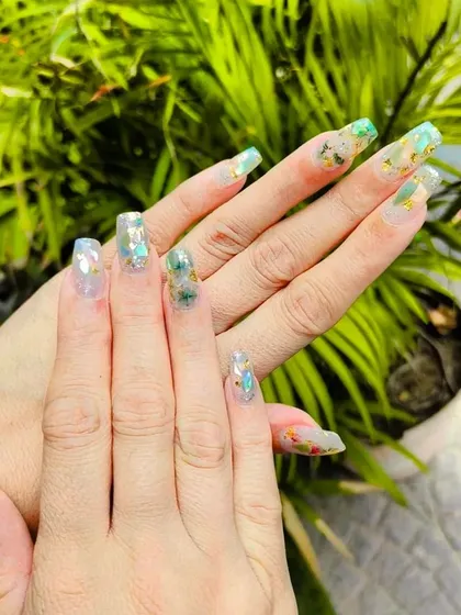A beautiful example of encapsulated art on a nude base. These long, clear extensions feature delicate green and gold flakes for an earthy, elegant look.