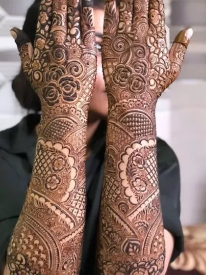 A beautiful, dense floral bridal mehendi that covers the hands and arms in a tapestry of flowers and leaves.