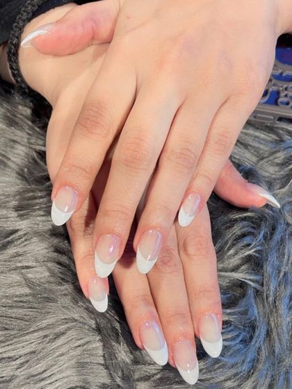 Another example of a timeless classic French manicure. The clean white tips on these long oval nails provide a fresh and polished look.