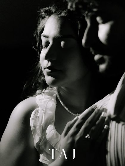An artistic black and white close-up, where light and shadow play across the bride's face. This shot is all about mood and emotion, capturing a quiet, introspective moment.
