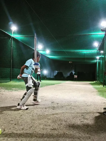 A young player getting one-on-one guidance under the floodlights. I ensure that every player, regardless of the time of day, gets focused attention.
