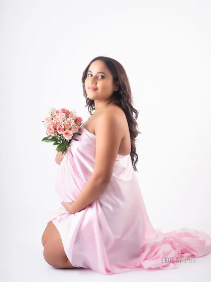 A beautiful seated pose with the pink drape. This allows for a different perspective and composition, creating a soft and romantic portrait.