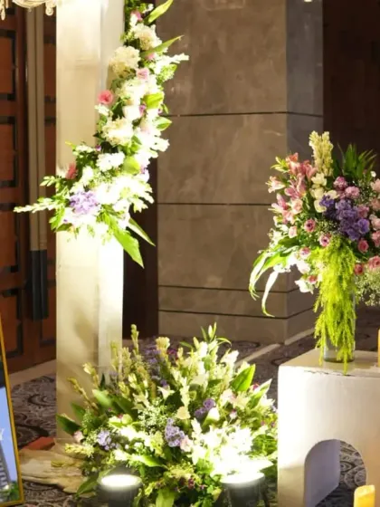 A closer look at the welcome area, highlighting the blend of modern signage and lush, classic floral arrangements.