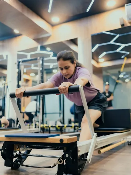 This client is performing an elephant stretch on the reformer, a great way to lengthen the hamstrings and spine while maintaining core control and precision.