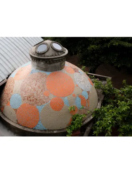 This whimsical, mosaic-covered dome is a distinct feature of the learning center's roofscape. It not only adds a playful visual element but also houses a space filled with natural light from its porthole-like windows.