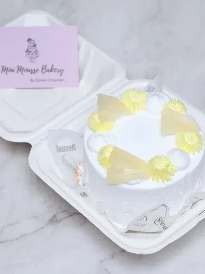 A pineapple-flavored bento cake, perfect for a tropical vibe. This mini cake is decorated with yellow frosting and delicate pineapple-shaped garnishes.