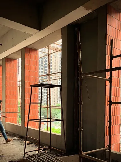 An interior view from the office tower during construction. The repeating brick piers create a strong sense of scale and rhythm, framing views of the city outside.