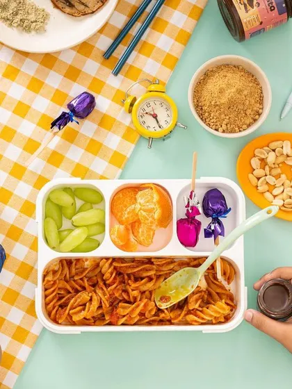 A playful and colorful flat lay for Feedsmart, showing a child's lunchbox with healthy snacks. This type of lifestyle photography is designed to appeal to parents looking for nutritious kids' food options.