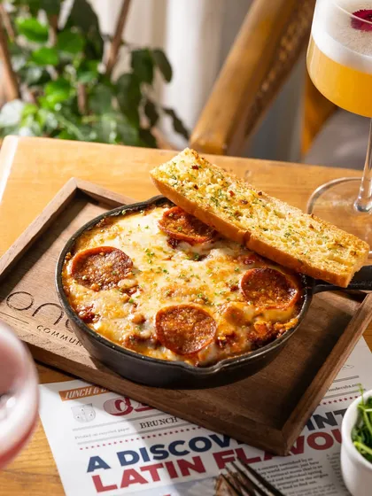 A sizzling skillet of pepperoni dip with garlic bread. This is pure comfort food, shot to look cheesy and irresistible.