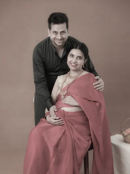 A timeless, sepia-toned portrait. This edit gives a classic, artistic feel to a traditional Indian maternity photo, highlighting the couple's elegant pose.