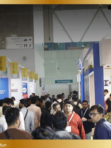 A dense crowd gathers around exhibitor booths, a clear indicator of the high engagement and interest from attendees.
