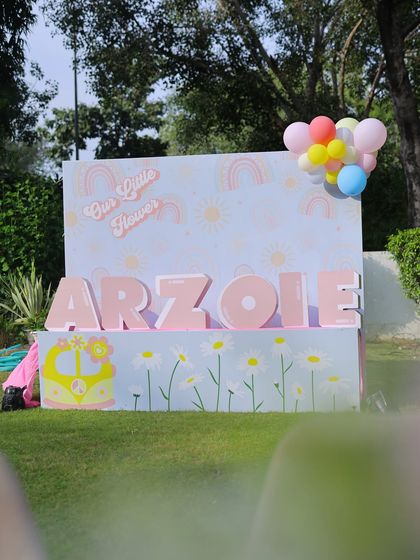 The full view of the personalized "Arzoie" name display, set against a backdrop of daisies and a groovy bus graphic.