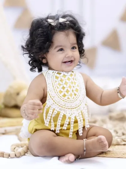 Celebrating the big 'ONE'. This little bub is all smiles in a rustic, boho-themed setup, perfect for a memorable first birthday photoshoot.
