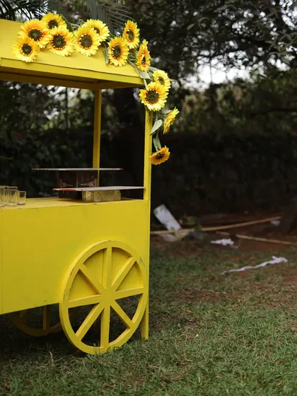 The sunflower cart, ready to serve guests. This functional decor piece adds to the overall 'sunflower paradise' theme of the event.