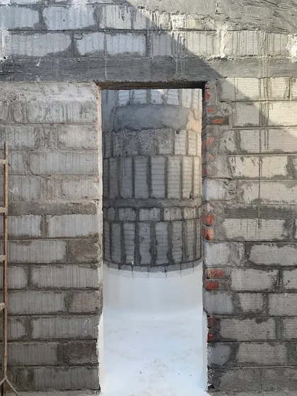 A view through a doorway at the House of Galleries, showing the interplay of flat planes and curved forms that define the project.