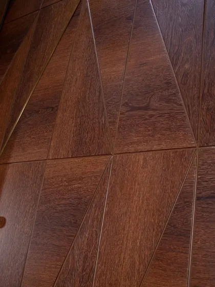 A close-up of the geometric pattern on the Sucupira veneer door. The high-gloss finish makes the metal inlays pop, creating a luxurious, jewel-like effect.
