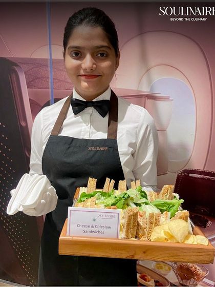 A member of our team offering a tray of classic Cheese & Coleslaw sandwiches. We provide a range of catering options, from simple and elegant to complex and gourmet.