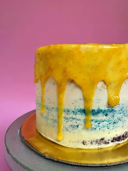 A close-up of the bright citrus curd dripping down the side of my Oranges & Lemons cake. It's as delicious as it looks.
