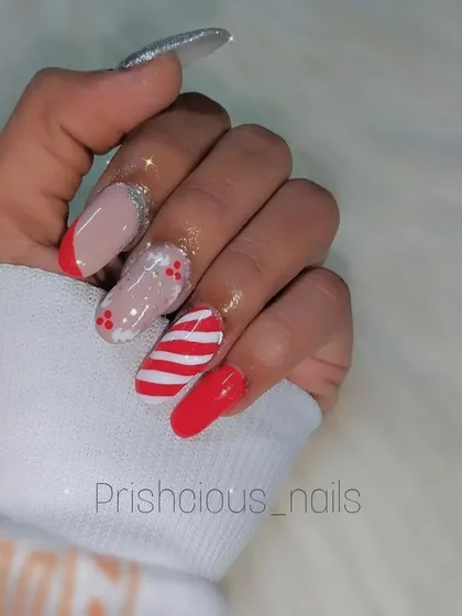 A classic Christmas candy cane nail set. This design features bold red, white stripes, glittery red French tips, and a silver glitter accent nail.