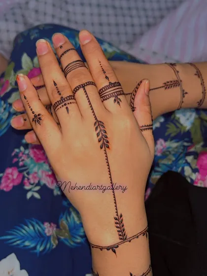 A very modern and linear design with leafy arrows and simple bands around the fingers and wrist.
