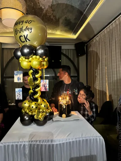 The cake-cutting moment at the 40th birthday party. The decor provides a stylish and celebratory backdrop for these important photos.